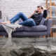 Man Sitting On Sofa Calling To Plumber